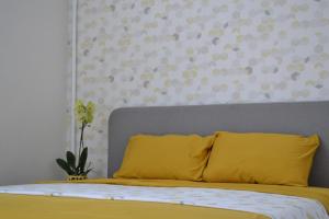 ein Bett mit gelbem Kissen in einem Schlafzimmer in der Unterkunft Honey Bunny in Krementschuk