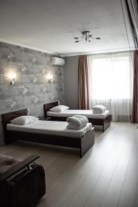 um quarto com três camas, uma janela e um sofá em Cocos Hotel em Rostov on Don