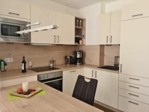 a kitchen with white cabinets and a table with a plate of fruit at Ferienwohnung Blickfang in Garmisch-Partenkirchen