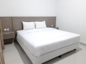 a bed with white sheets and pillows in a bedroom at Joglo 21A in Yogyakarta