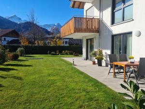 a patio with a table and chairs in a yard at Ferienwohnung Blickfang in Garmisch-Partenkirchen