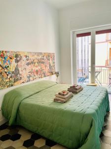 ein Schlafzimmer mit einem grünen Bett und Handtüchern darauf in der Unterkunft chiesa russa in Bari