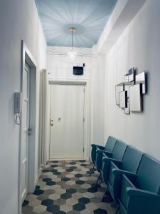 a waiting room with blue chairs and a door at chiesa russa in Bari
