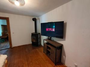 ein Wohnzimmer mit einem Flachbildfernseher an der Wand in der Unterkunft Gemütliche Ferienwohnung mit Kamin und Garten in Garmisch-Partenkirchen