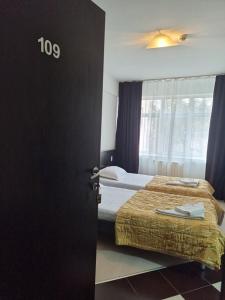 a bedroom with two beds and a door with the number at Hotel Vaslui in Vaslui