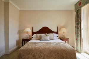 ein Schlafzimmer mit einem großen Bett mit zwei Lampen und einem Fenster in der Unterkunft Macdonald Bath Spa Hotel in Bath