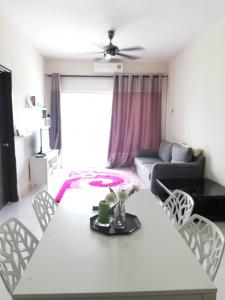 uma sala de estar com uma mesa branca e cadeiras em Ijanina Homestay em Bandar Puncak Alam