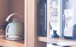 a tea kettle sitting on a shelf next to a bottle of wine at Napoli Visit Home in Naples