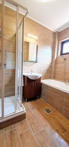 a bathroom with a tub and a sink and a shower at Varga Gardens Balatonmáriafürdő in Balatonmáriafürdő +65 photos