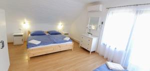 a bedroom with a bed and a dresser and a window at Varga Gardens Balatonmáriafürdő in Balatonmáriafürdő