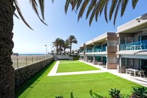 anterior view of a building with a lawn and the beach at ConMar in San Agustin