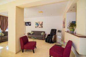 sala de estar con sillas rojas y sofá en Playa Bay Hotel Zakynthos en Laganas