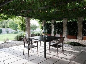 een zwarte tafel en stoelen op een patio bij House Wisteria in Kostanjevica na Krasu