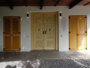 two wooden doors on the side of a house at House Wisteria in Kostanjevica na Krasu