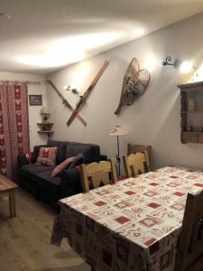 ein Wohnzimmer mit einem Tisch und einem Sofa in der Unterkunft Appartement duplex 7 pers 3 chambres pied des pistes La Joue du Loup in Le Dévoluy