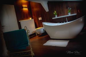 uma casa de banho com uma banheira branca num piso de madeira em Villa Prestige em Zeitz