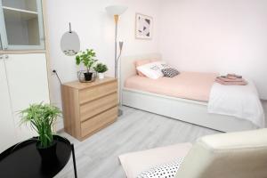 um pequeno quarto com uma cama e uma cómoda em Apartament Słoneczny em Gdynia