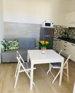 a white table and chairs in a kitchen with a couch at CasaAle in Anacapri