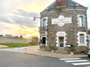 a stone building with a sign on the side of a street at Hôtel des quatre saisons in Guérande