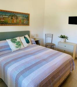 a bedroom with a bed and a painting on the wall at CasaAle in Anacapri