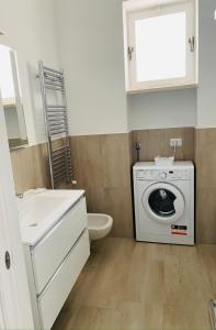ein Badezimmer mit einer Waschmaschine und einem Waschbecken in der Unterkunft CasaAle in Anacapri