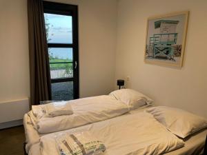 Bett in einem Zimmer mit Fenster in der Unterkunft Traum Chalet am Ijsselmeer in Enkhuizen