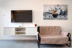 a living room with a tv and a chair at coral suite new vacation apartment in Eilat