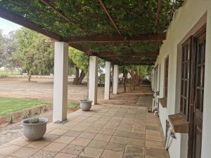 an outdoor walkway with a pergola on a building at Kleine Kaap - Selfsorg in Orania