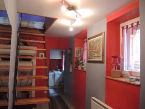 a room with red walls and a staircase in a room at GITE le 70 à TURCKHEIM, 10 min Colmar in Turckheim