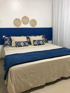 Un dormitorio con una cama azul y blanca con almohadas en Terra Bahia, en Aracaju
