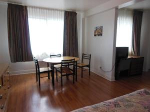 a dining room with a table and chairs in a room at Motel Pierre in Montreal