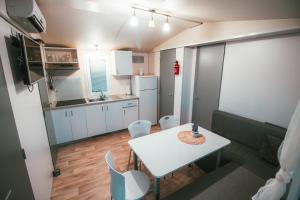uma pequena cozinha com uma mesa branca e cadeiras em Holiday cottage with 2 Thermal Riviera Tickets em Moravske-Toplice