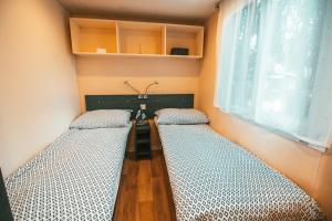 duas camas num quarto com uma mesa e uma janela em Holiday cottage with 2 Thermal Riviera Tickets em Moravske-Toplice