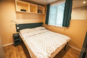 a small bedroom with a bed and a window at Holiday cottage with 2 Thermal Riviera Tickets in Moravske Toplice