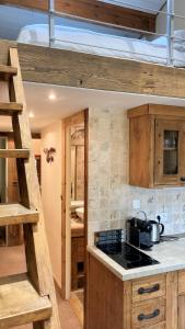 La cuisine est équipée de placards en bois et d'un four avec plaques de cuisson. dans l'établissement Oree Studio Mezzanine, à Megève