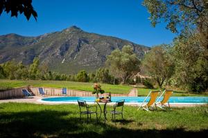 a table and chairs in the grass near a pool at Casa vacanze Maria Maddalena Iglesias in Iglesias