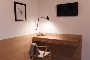 Habitación con escritorio, TV y silla. en Piltriquitron Lodging, en Sankt Anton am Arlberg