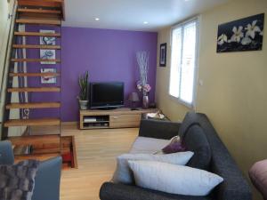 a living room with a couch and a tv at GITE le 70 à TURCKHEIM, 10 min Colmar in Turckheim