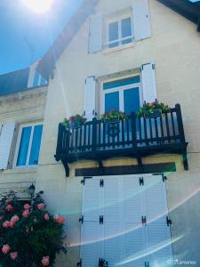 - un bâtiment avec un balcon fleuri dans l'établissement Les Tourterelles, à Vendôme