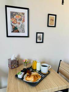 a breakfast tray with a croissant and coffee on a table at Les Tourterelles in Vendôme
