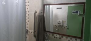 uma casa de banho com um chuveiro, um espelho e um lavatório. em Habita Estudios Laureles em Medellín