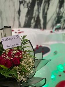 um ramo de flores e um cartaz na mesa em السامية الفندقية em Sharurah