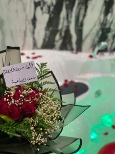 a bouquet of flowers and a sign on a table at السامية الفندقية in Sharurah