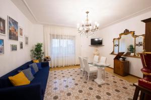 sala de estar con sofá azul y mesa en Non ti scordar di me - Granny's House, en Roma