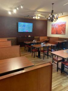 een restaurant met tafels en stoelen en een flatscreen-tv bij Zion's Most Wanted Hotel in Hildale