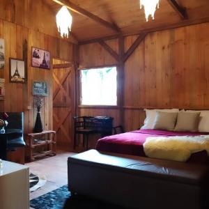 a bedroom with a bed in a wooden cabin at Espaço Rural Sítio Do Sol in Guabiruba