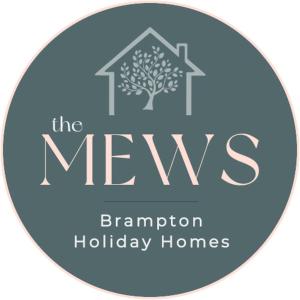 a blue logo for the mews barrington holiday homes at Brampton Holiday Homes - The Mews Apartment in Brampton