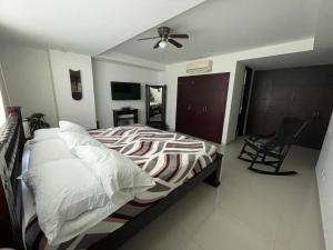 1 dormitorio con 1 cama y ventilador de techo en Cartagena Beach Front Apartments, en Cartagena de Indias