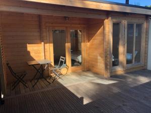 eine Holzhütte mit einem Tisch und Stühlen auf einer Terrasse in der Unterkunft Chalet de La Source in Rognac