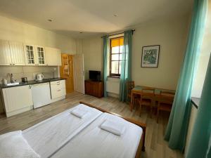 a bedroom with a bed and a kitchen with a table at Apartamenty Przy Parku in Rabka